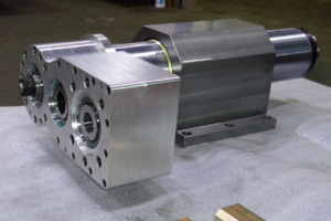 Gear box with motor mount at left, quill clamp housing in center and spindle nose at right