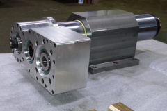 Gear box with motor mount at left, quill clamp housing in center and spindle nose at right