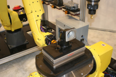 M20iA Robot placing part and Hirschmann pallet on Hirshmann pnuematic chuck via 2-Axis postioner for presentation to MC40 spindle endmill machining.